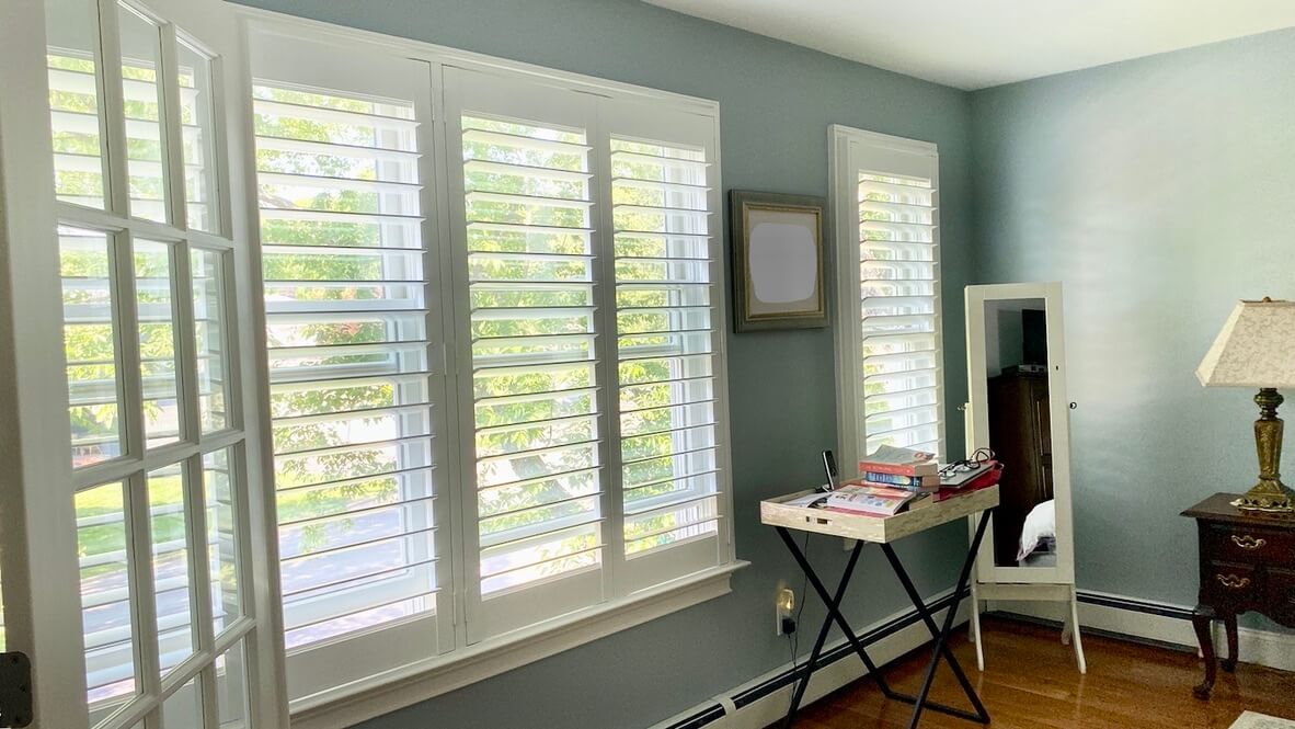 White plantation-style custom shutters on a sunlit Brookhaven home office window