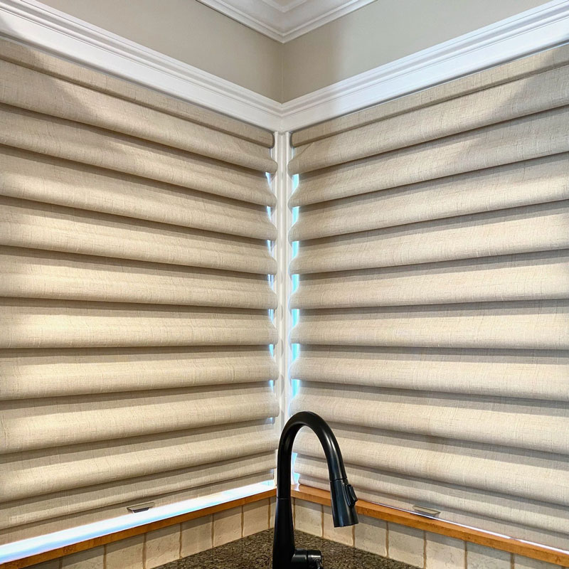 Cordless Roman-style shades in a Hamptons kitchen corner with soft beige fabric and clean folds